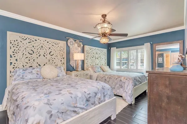 a bed sitting in a bedroom next to a book shelf