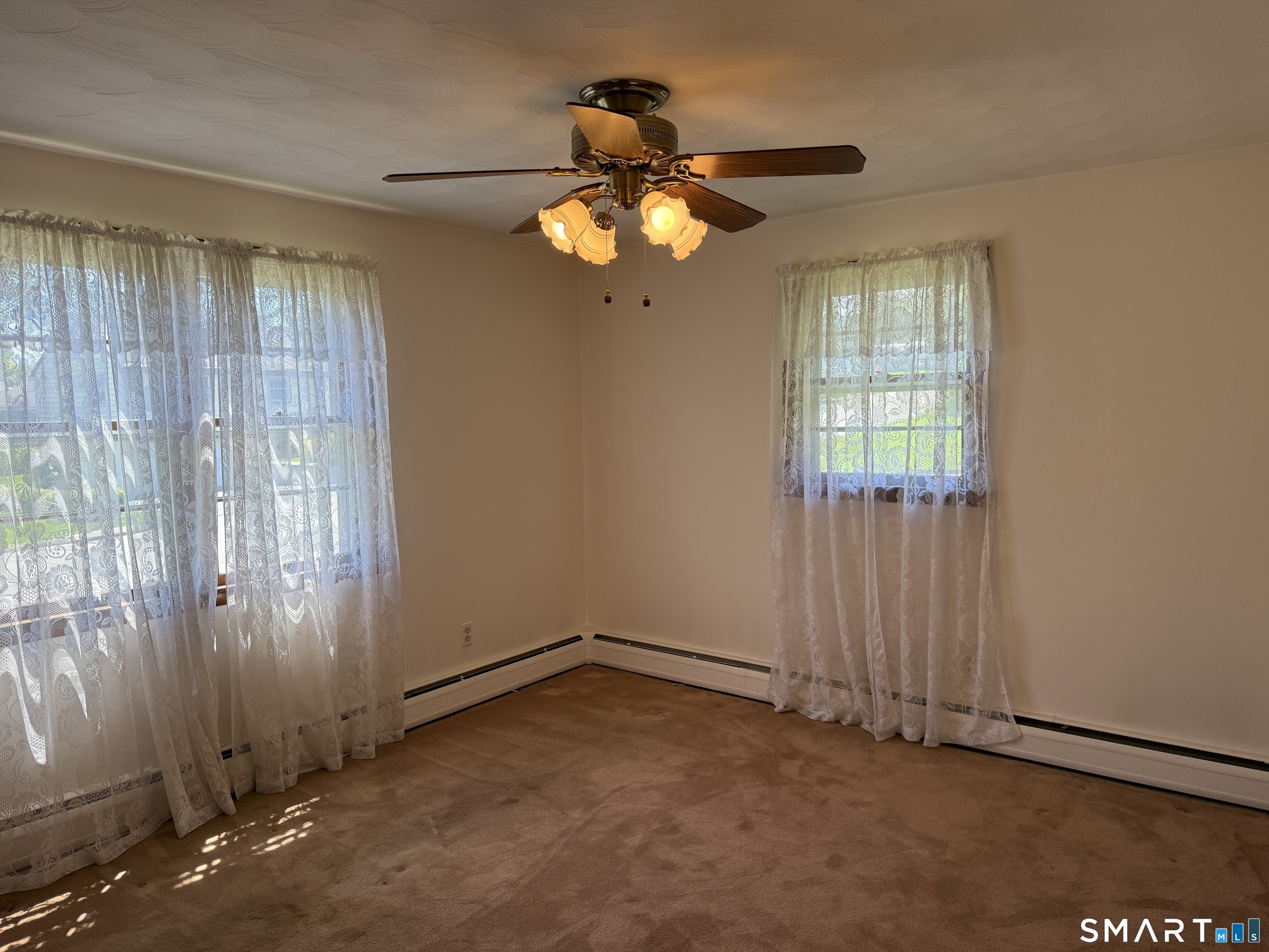 26 Maple Street Trumbull, CT 06611 - Photo 32 of 37 an empty room with windows and chandelier fan