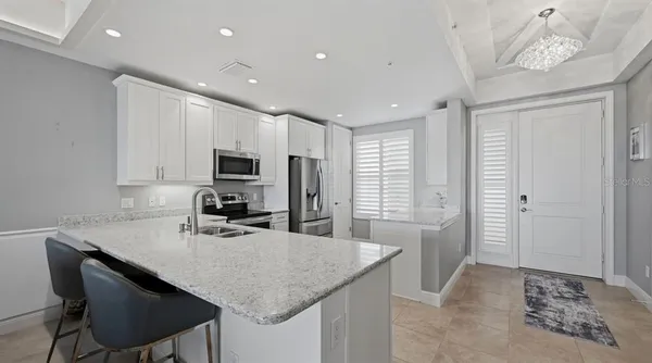 a kitchen with kitchen island granite countertop a sink cabinets and refrigerator