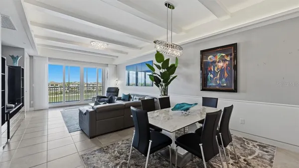 a view of a dining room with furniture a rug and a chandelier