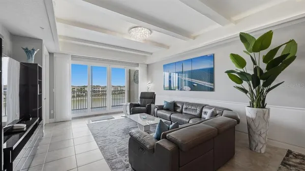 a living room with furniture a chandelier and a flat screen tv