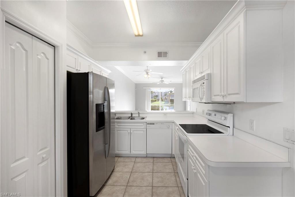 8550 Kingbird Loop, Unit 615 Estero, FL 33967 - Photo 22 of 35 a kitchen with a sink a refrigerator and cabinets