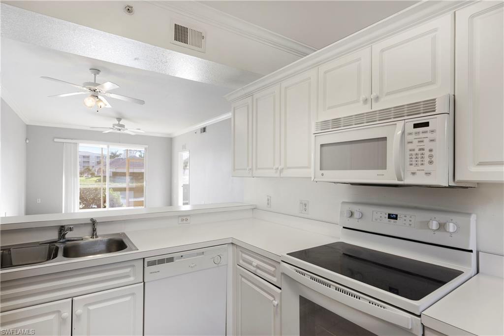 8550 Kingbird Loop, Unit 615 Estero, FL 33967 - Photo 24 of 35 a kitchen with granite countertop white cabinets white stainless steel appliances and sink