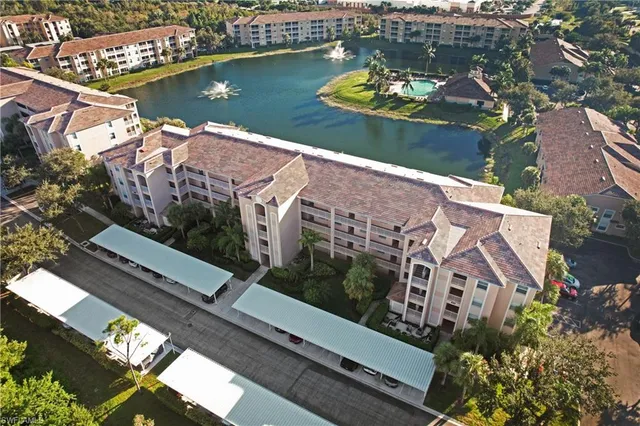 an aerial view of a house with a yard and lake view