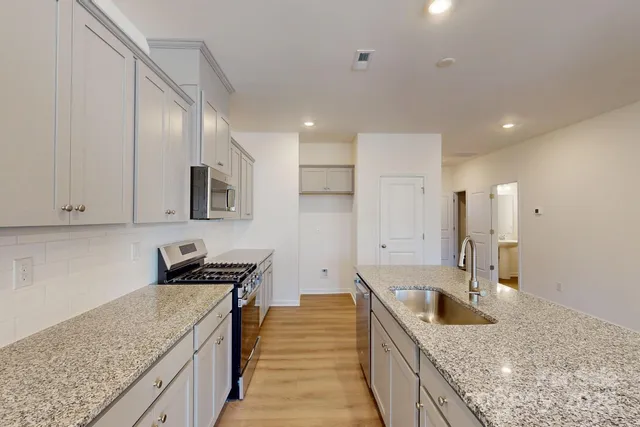 a kitchen with a sink stove and cabinets