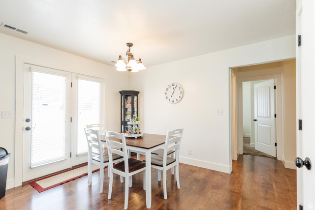 1145 West 2640th Street South Logan, UT 84321 - Photo 6 of 17 Dining area featuring dark wood-finish flooring, white baseboards, and a chandelier with glass shades