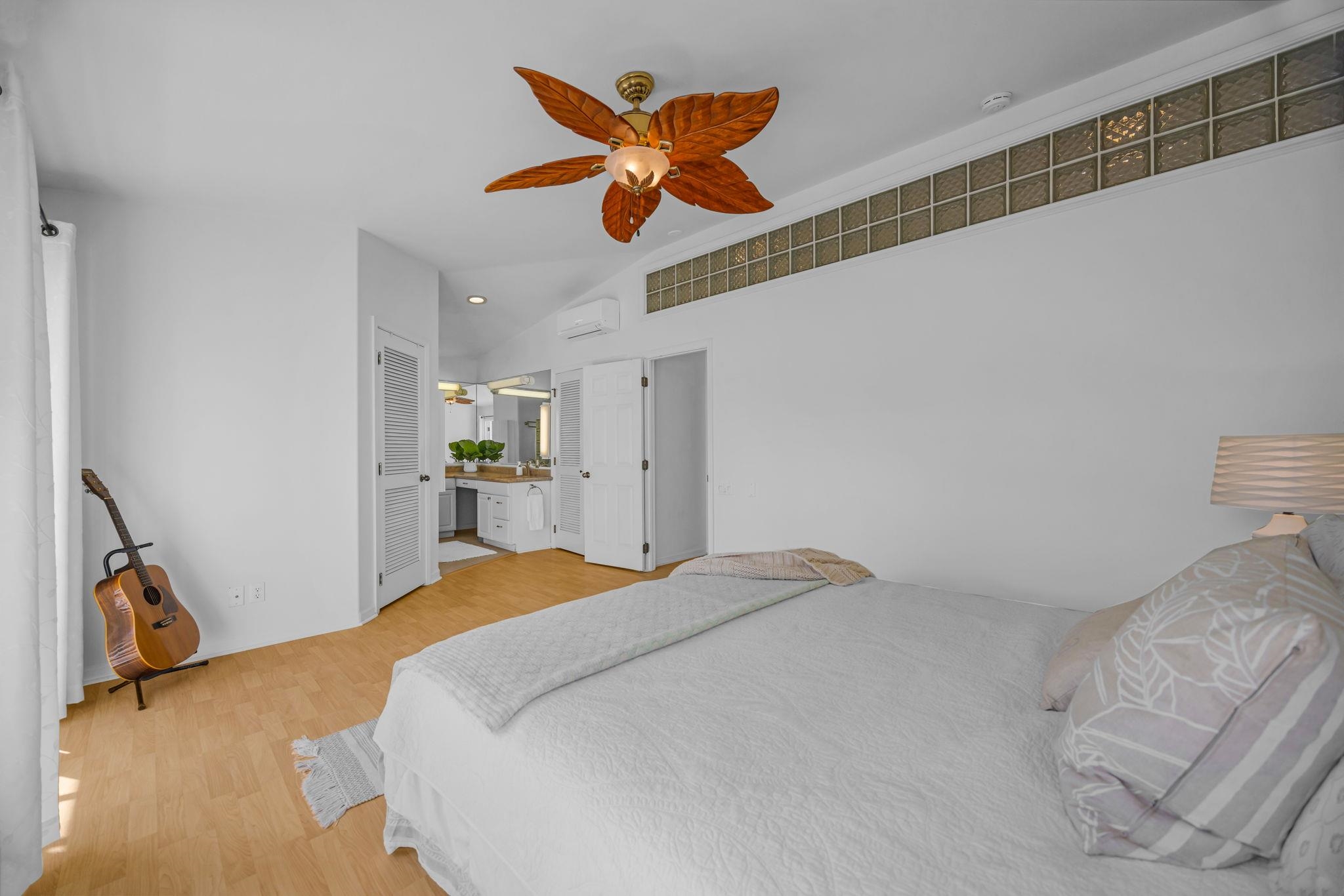 235 Keonekai Road Kihei, HI 96753 - Photo 24 of 50 a bedroom with a bed and a chandelier