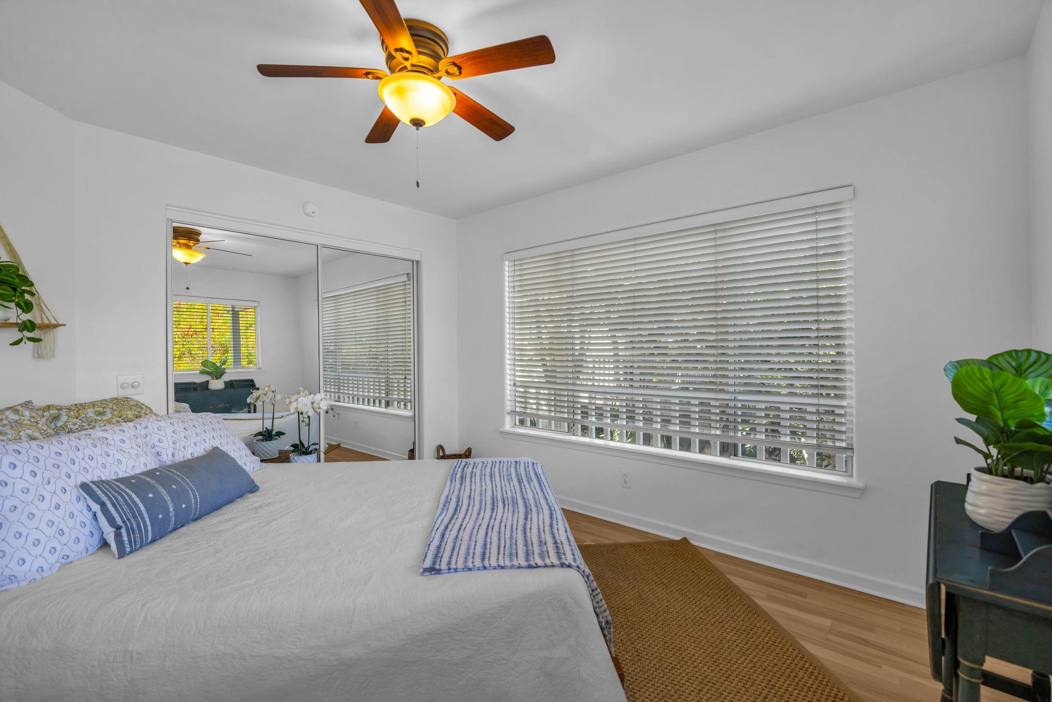 235 Keonekai Road Kihei, HI 96753 - Photo 40 of 50 a spacious bedroom with a large bed a chandelier and a window