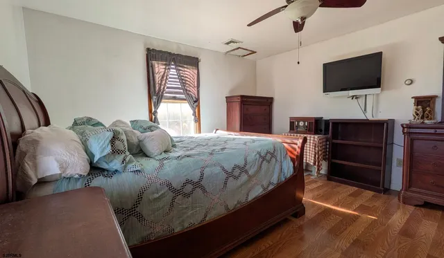 a spacious bedroom with a bed and a flat screen tv