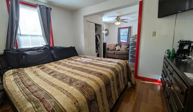 a bedroom with a bed and a flat tv screen next to a window