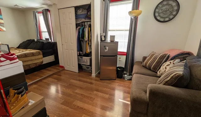 a living room with furniture a refrigerator and a flat screen tv