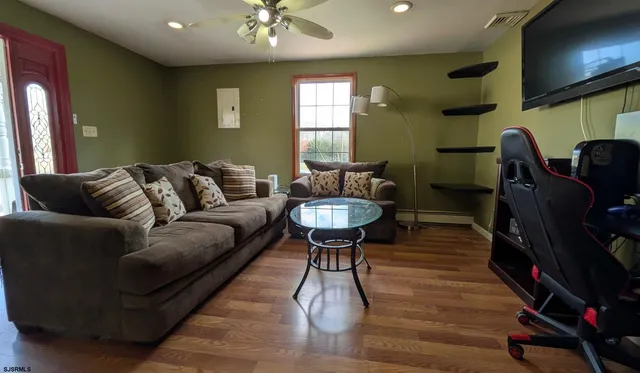 a living room with furniture a flat screen tv and kitchen view