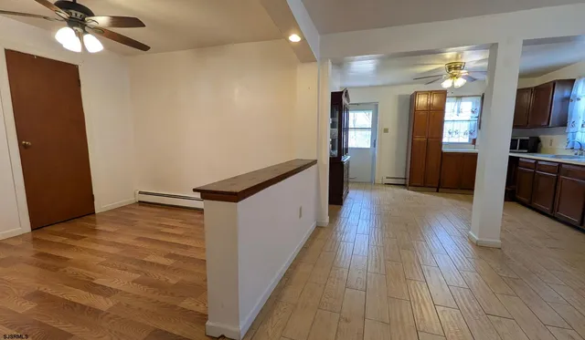 a view of a hallway with wooden floor and staircase