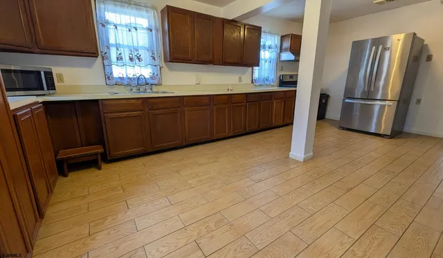 a kitchen with stainless steel appliances granite countertop a refrigerator and a sink