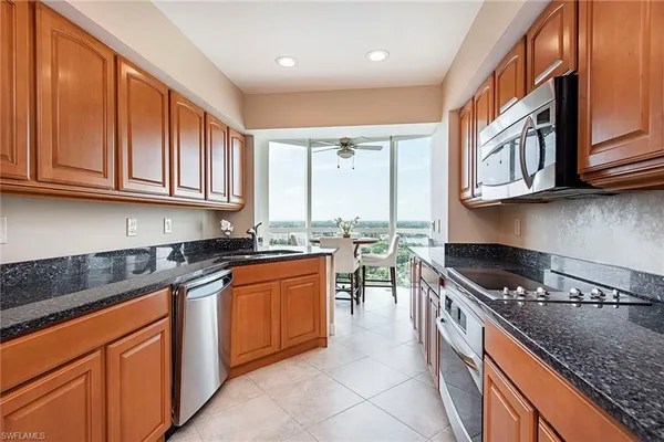a kitchen with stainless steel appliances granite countertop a stove a sink and a microwave