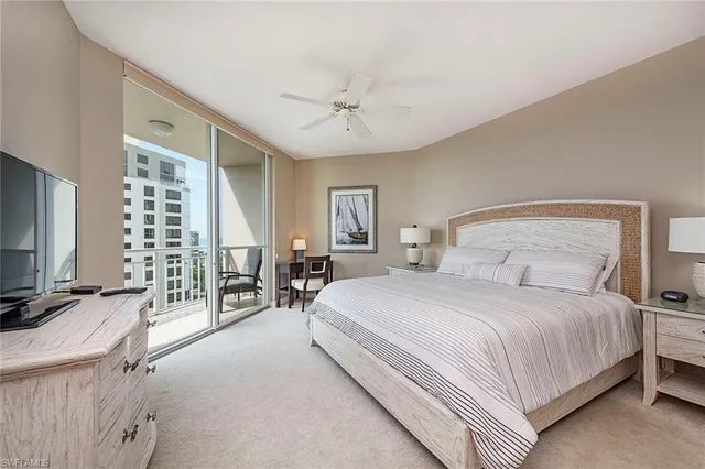 a bedroom with a large bed and a chandelier