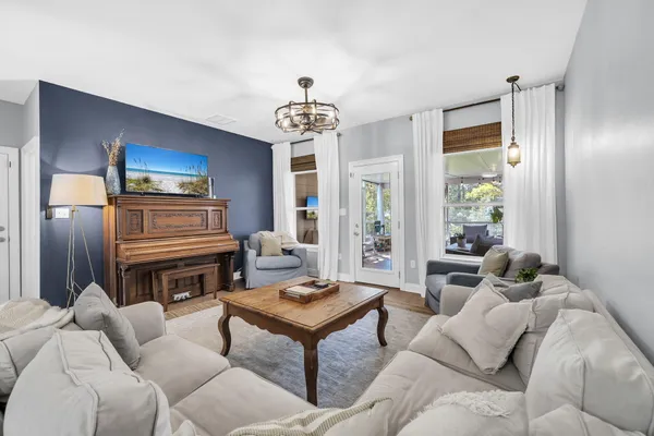 a living room with furniture a chandelier and a flat screen tv