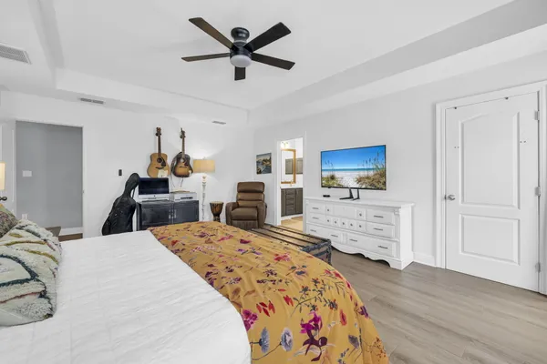 a bed room with a bed a dresser and a flat screen tv