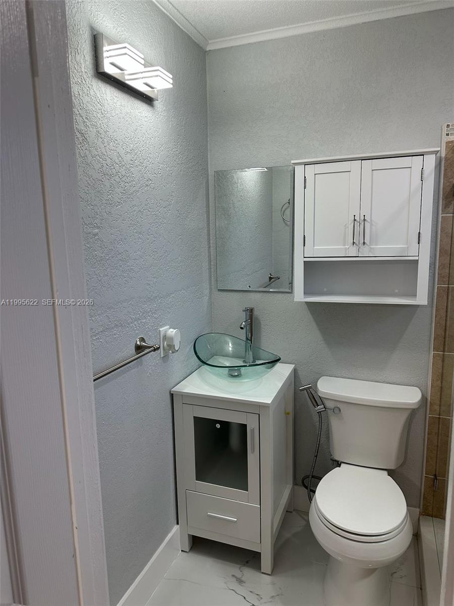 10745 Southwest 222nd Street, Unit 10745 Miami, FL 33170 - Photo 15 of 26 a bathroom with a toilet sink and cabinets