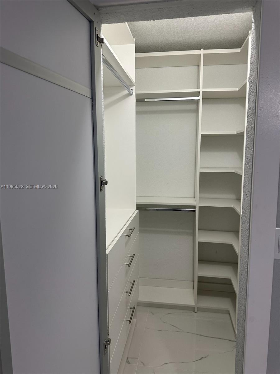 10745 Southwest 222nd Street, Unit 10745 Miami, FL 33170 - Photo 18 of 26 a view of walk in closet with empty racks