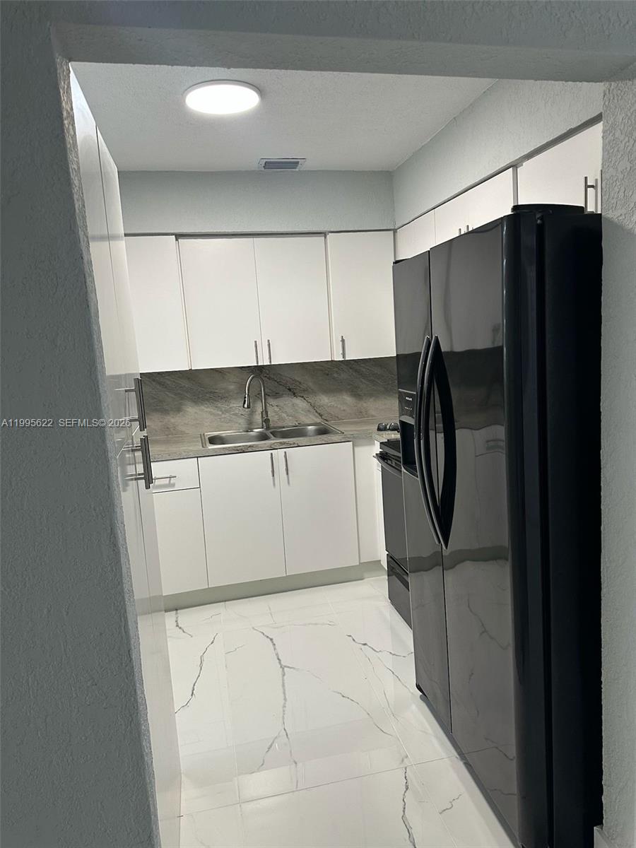 10745 Southwest 222nd Street, Unit 10745 Miami, FL 33170 - Photo 8 of 26 a kitchen with a refrigerator and a sink
