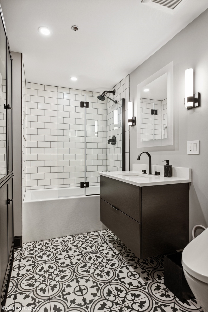 850 West Adams Street, Unit 2E Chicago, IL 60607 - Photo 30 of 36 a bathroom with a bathtub sink mirror and toilet