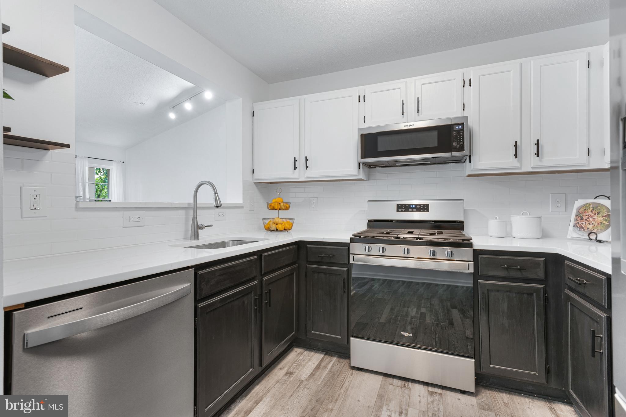 12004 Taliesin Place, Unit 32 Reston, VA 20190 - Photo 11 of 26 a kitchen with cabinets appliances a sink and a counter top space