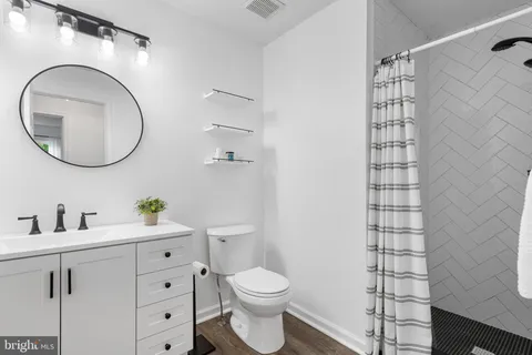 a bathroom with a toilet a sink and mirror