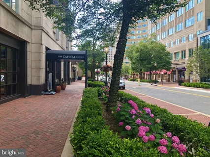 a front view of building with flowers and trees
