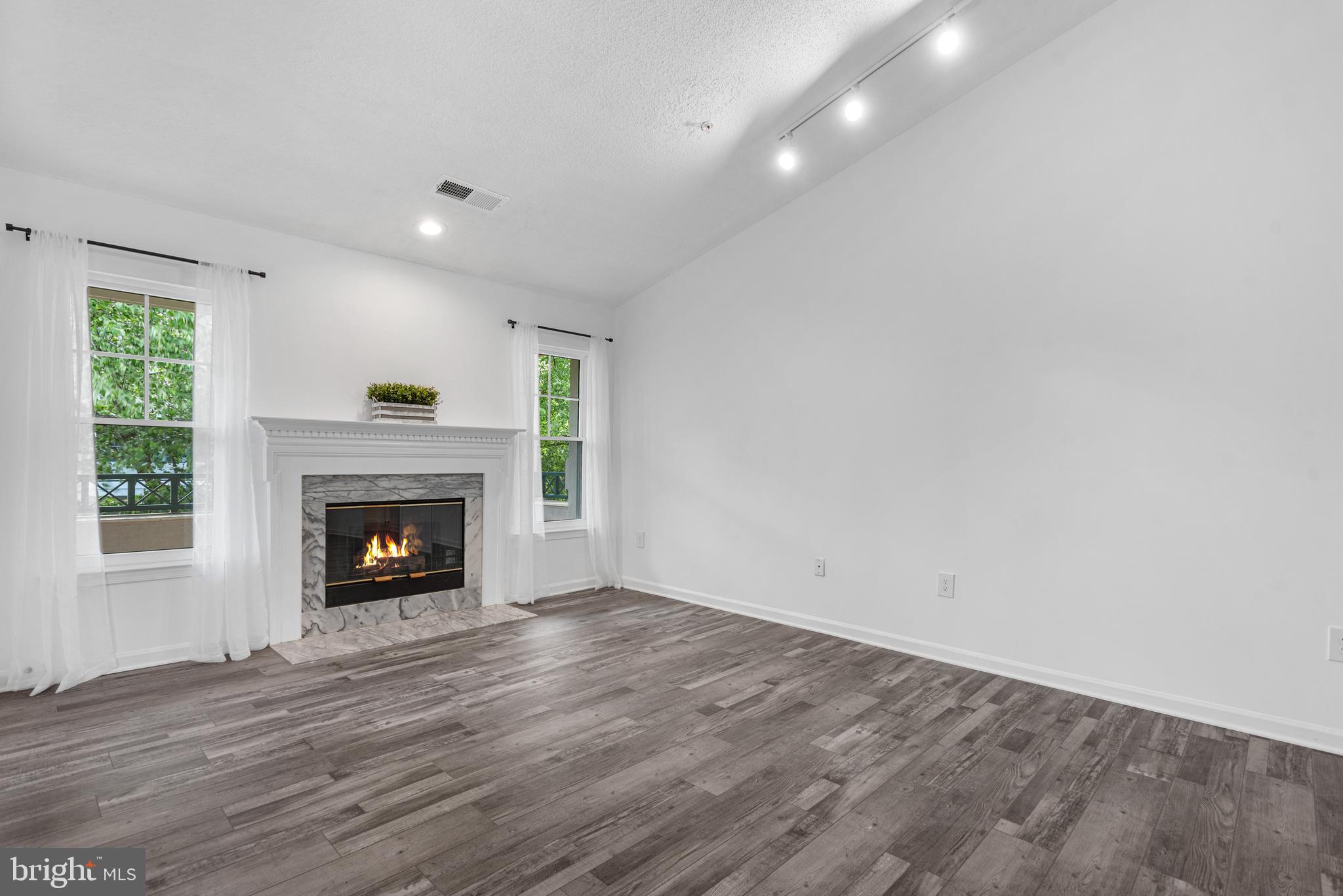12004 Taliesin Place, Unit 32 Reston, VA 20190 - Photo 5 of 26 a view of an empty room with wooden floor fireplace and a window
