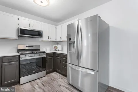 a kitchen with stainless steel appliances a refrigerator sink and microwave