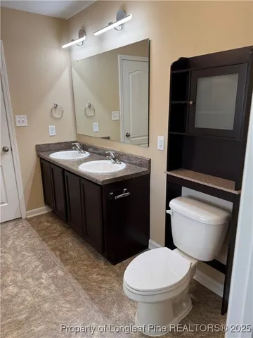 a bathroom with a toilet a sink and mirror