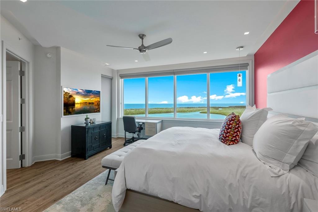275 Indies Way, Unit 1701 Naples, FL 34110 - Photo 21 of 32 a bedroom with a large bed and a flat tv screen on dresser