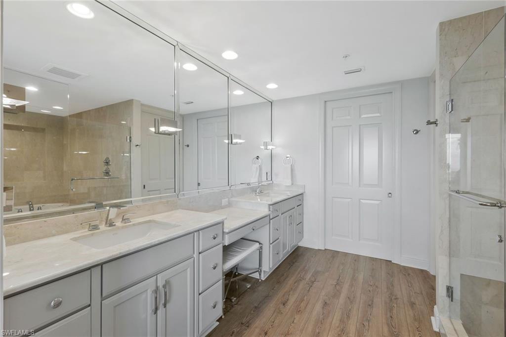 275 Indies Way, Unit 1701 Naples, FL 34110 - Photo 22 of 32 a bathroom with a double vanity sink a mirror and a shower