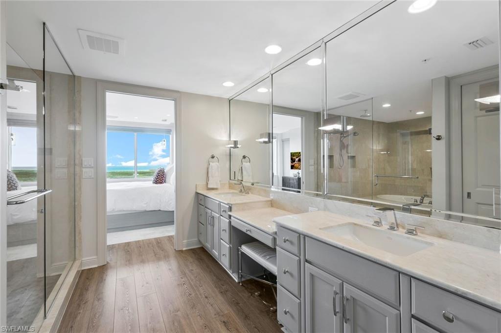275 Indies Way, Unit 1701 Naples, FL 34110 - Photo 23 of 32 a bathroom with a sink double vanity granite tub shower and a mirror