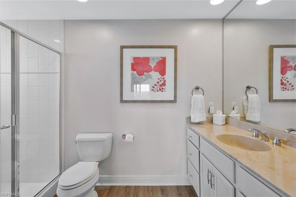 275 Indies Way, Unit 1701 Naples, FL 34110 - Photo 25 of 32 a bathroom with a toilet sink and mirror