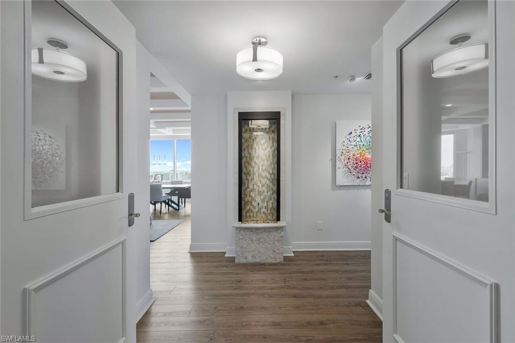 275 Indies Way, Unit 1701 Naples, FL 34110 - Photo 3 of 32 a view of a hallway with wooden floor and a bathroom