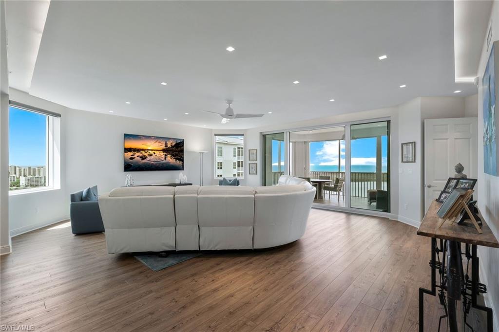 275 Indies Way, Unit 1701 Naples, FL 34110 - Photo 8 of 32 a living room with furniture wooden floor and a flat screen tv