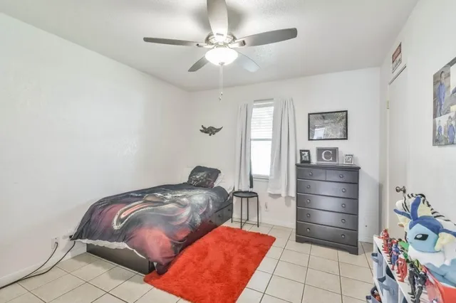 a bedroom with furniture and a chandelier fan