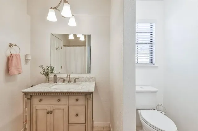 a bathroom with a sink a toilet and a mirror