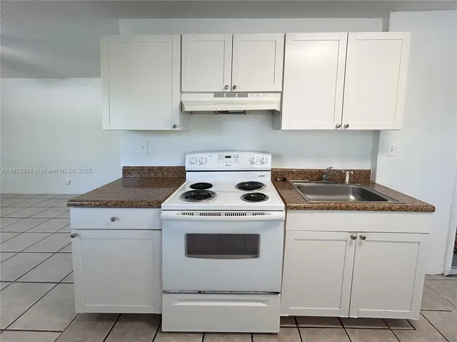 a white stove top oven sitting inside of a kitchen