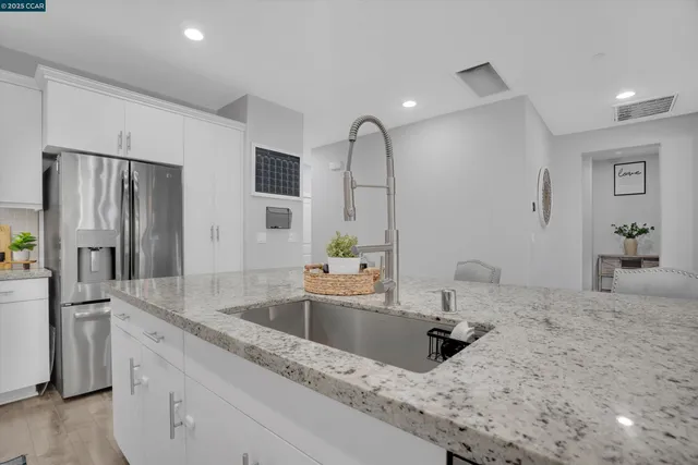 a kitchen with stainless steel appliances granite countertop a sink and a refrigerator