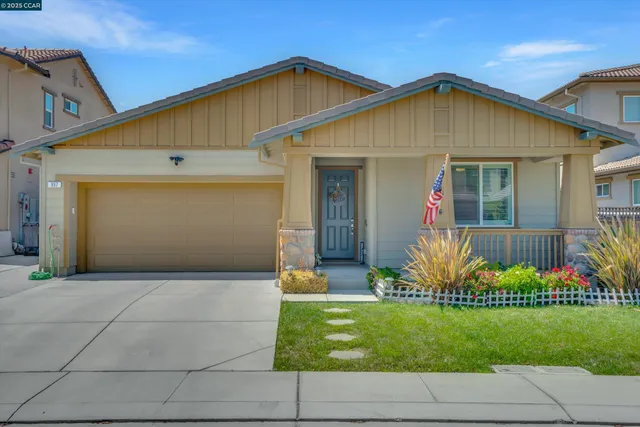 a front view of a house with a yard and potted plants