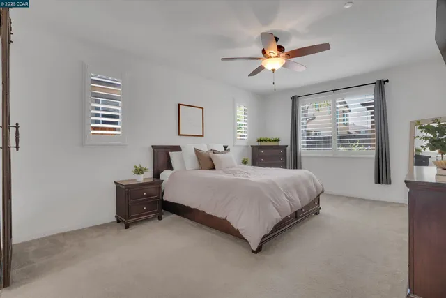 a spacious bedroom with a bed and a ceiling fan