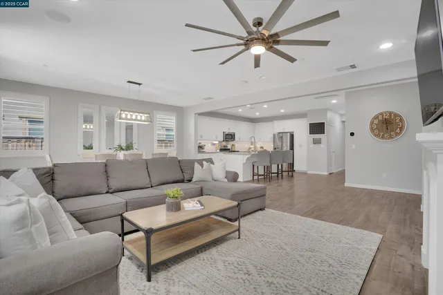a living room with furniture a view of bedroom and a ceiling fan