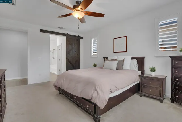 a spacious bedroom with a bed and a chandelier