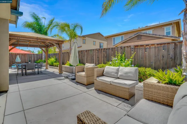 a view of a patio with couches table and chairs with potted plants