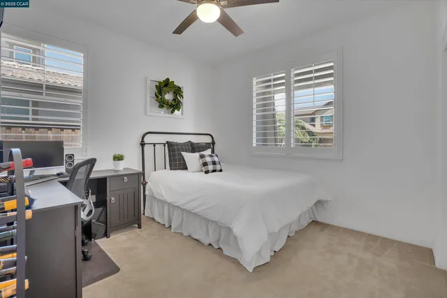 a bedroom with a bed workspace and window