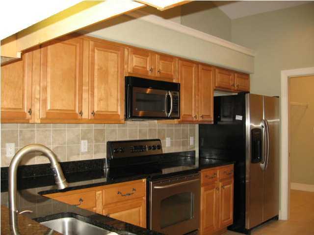 263 Diamond Cove, Unit 263 Destin, FL 32541 - Photo 4 of 24 a kitchen with stainless steel appliances granite countertop a stove a refrigerator and a microwave
