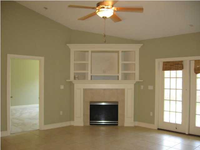 263 Diamond Cove, Unit 263 Destin, FL 32541 - Photo 5 of 24 a living room with a fireplace and chandelier
